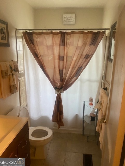 bathroom with tile patterned flooring, vanity, curtained shower, and toilet