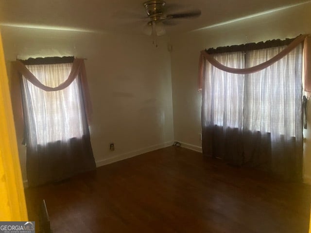 unfurnished room with ceiling fan, a healthy amount of sunlight, and dark hardwood / wood-style floors