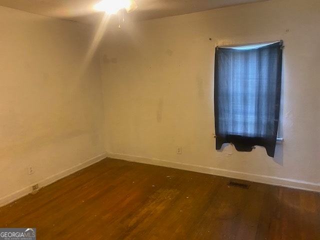 unfurnished room featuring ceiling fan and dark wood-type flooring