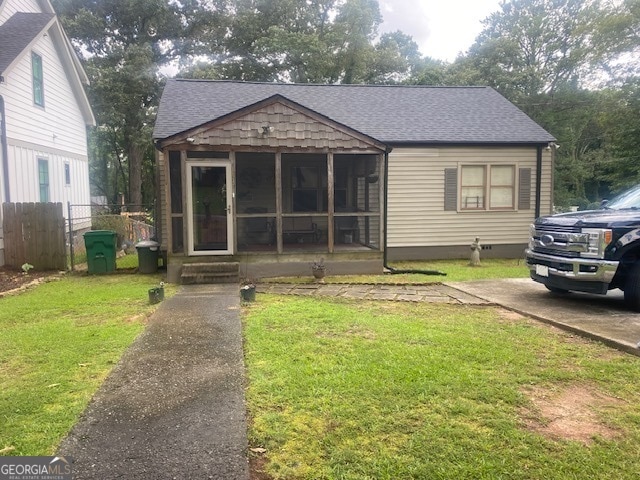 bungalow with a sunroom and a front lawn