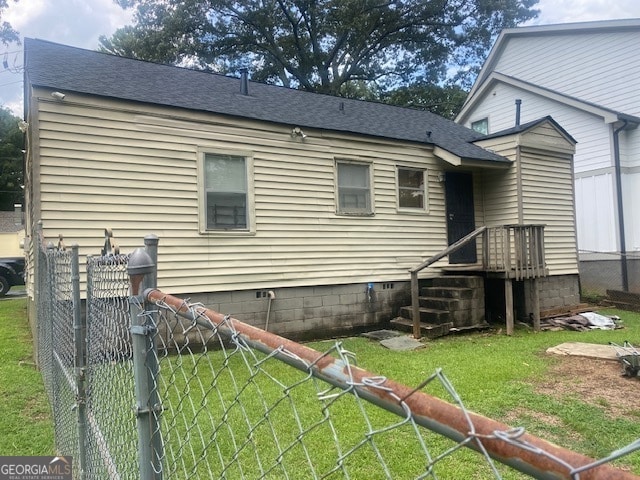 rear view of house featuring a lawn