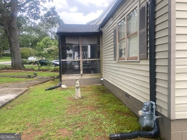 view of side of property featuring a sunroom and a yard