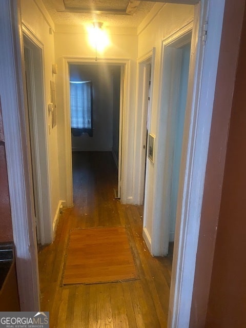 hallway with wood-type flooring and a textured ceiling