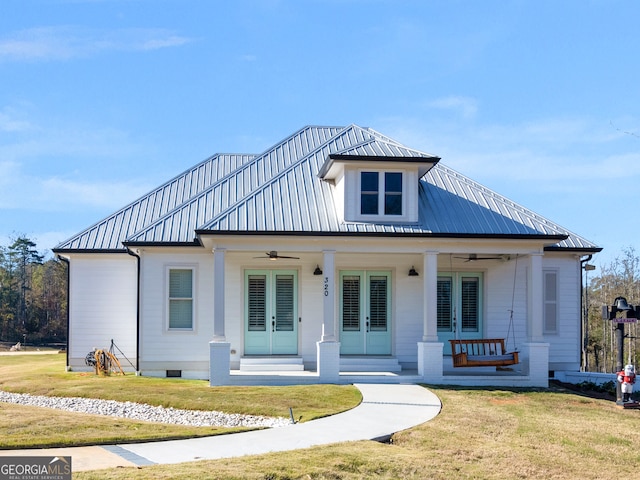 view of front facade featuring ceiling fan, french doors, covered porch, and a front yard