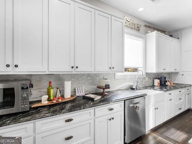 kitchen featuring dark hardwood / wood-style flooring, stainless steel appliances, white cabinetry, and tasteful backsplash