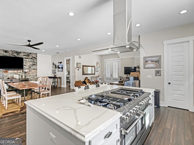 kitchen with double oven range, white cabinets, dark hardwood / wood-style floors, ceiling fan, and light stone counters