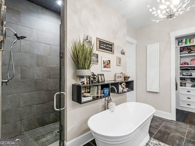 bathroom featuring tile patterned flooring, independent shower and bath, and a notable chandelier