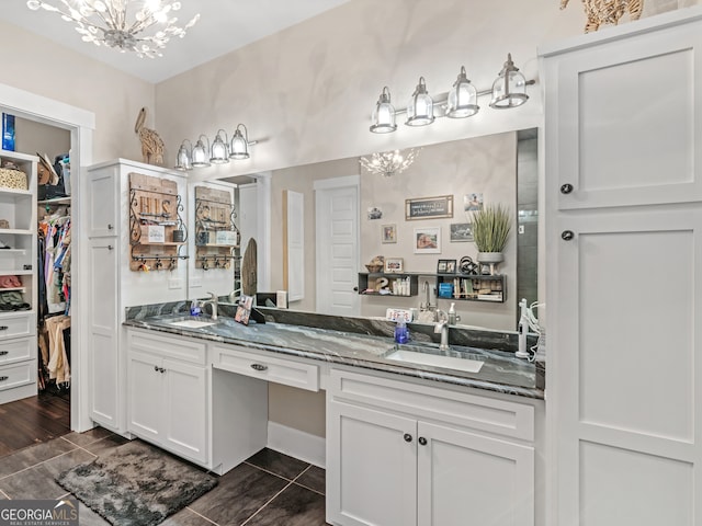 bathroom with vanity, wood-type flooring, and an inviting chandelier