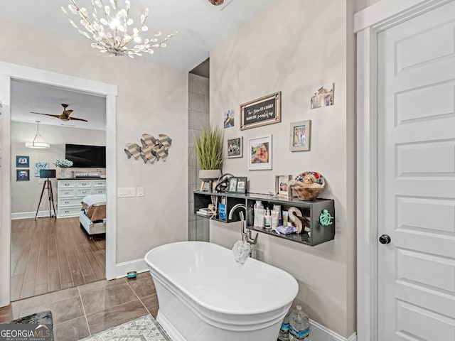 bathroom featuring a bathing tub, wood-type flooring, and ceiling fan with notable chandelier