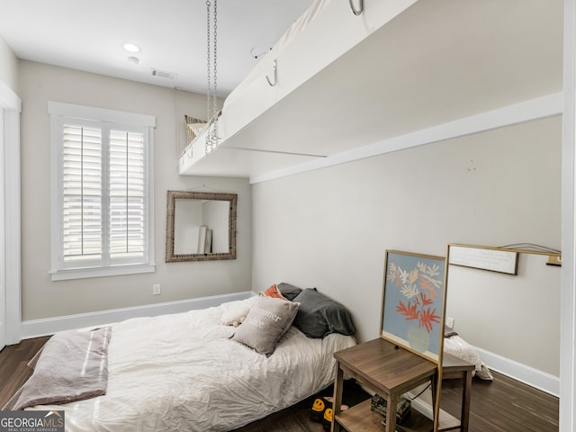 bedroom with dark hardwood / wood-style floors