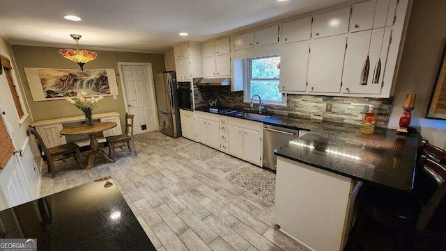 kitchen featuring white cabinetry, sink, light hardwood / wood-style flooring, crown molding, and appliances with stainless steel finishes