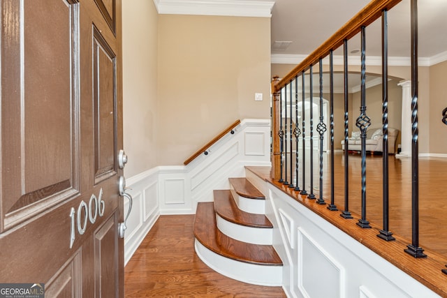 entryway featuring wood-type flooring and crown molding