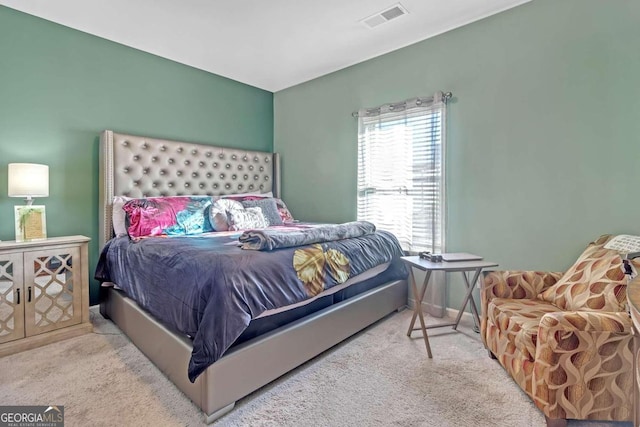 carpeted bedroom featuring visible vents