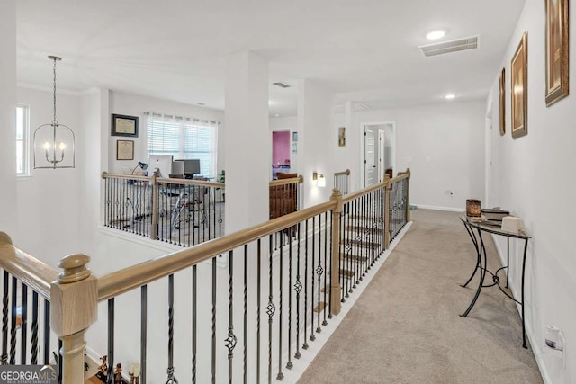 corridor with an upstairs landing, carpet flooring, a chandelier, baseboards, and visible vents