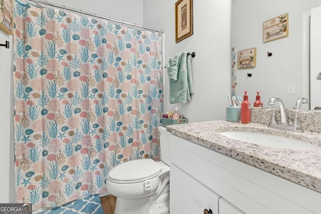 bathroom with a shower with shower curtain, toilet, and vanity