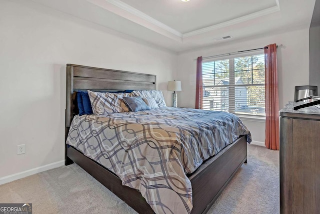 carpeted bedroom with baseboards, visible vents, crown molding, and a raised ceiling