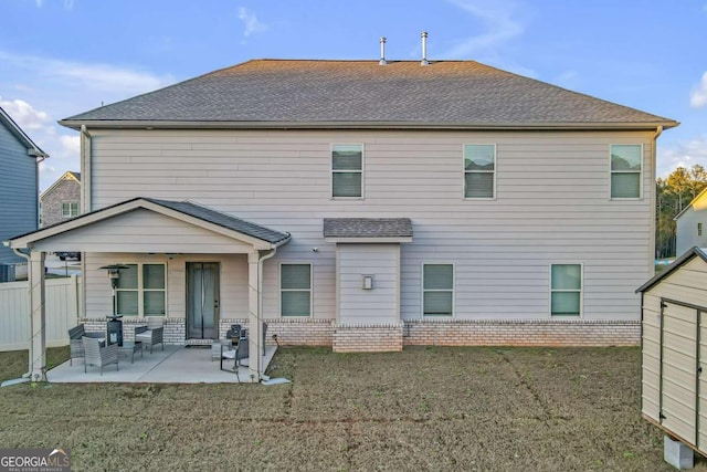 back of house featuring a patio, a shingled roof, fence, and a yard