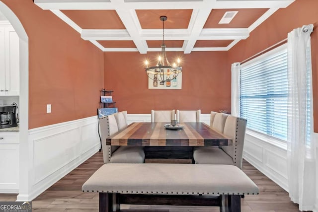 dining room featuring arched walkways, visible vents, an inviting chandelier, and light wood-style floors