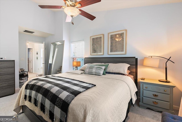 carpeted bedroom with ceiling fan and a towering ceiling