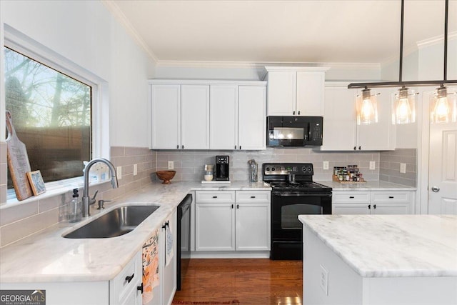 kitchen with light stone countertops, white cabinetry, sink, pendant lighting, and black appliances