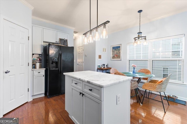 kitchen featuring white cabinetry, dark hardwood / wood-style flooring, decorative light fixtures, black fridge with ice dispenser, and a kitchen island