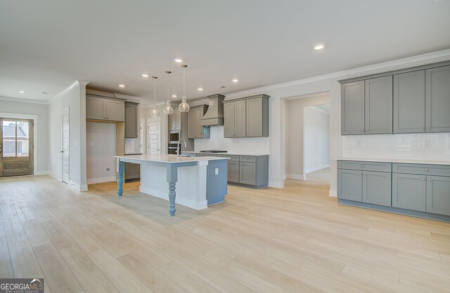 kitchen featuring white cabinetry, sink, stainless steel dishwasher, a kitchen island with sink, and a fireplace