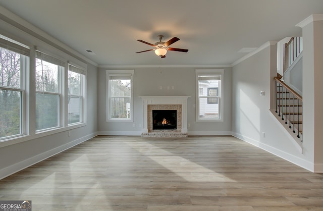 unfurnished living room featuring light hardwood / wood-style flooring, plenty of natural light, crown molding, and ceiling fan