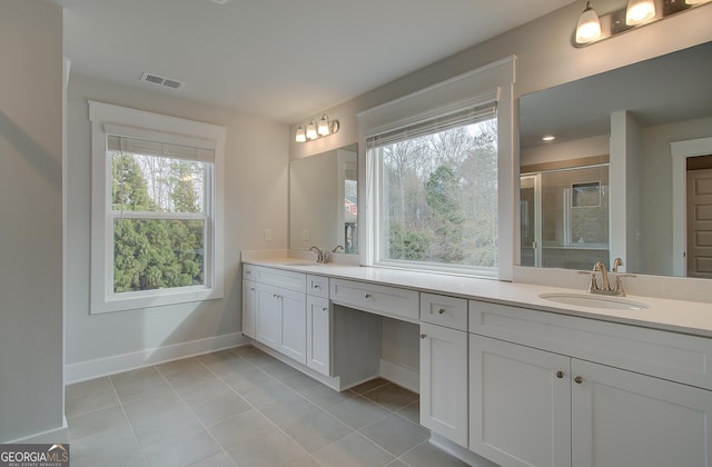 bathroom featuring tile patterned floors, vanity, and a shower with shower door