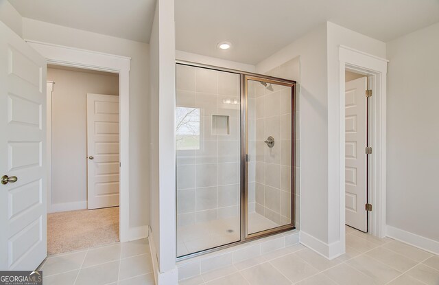 bathroom featuring tile patterned floors, vanity, toilet, and a shower with door