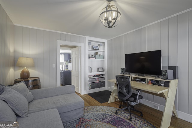 home office featuring ornamental molding, dark hardwood / wood-style floors, built in features, and a notable chandelier