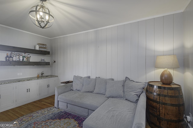 living room with dark wood-type flooring, ornamental molding, and bar area