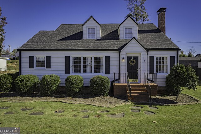 cape cod house with a front lawn