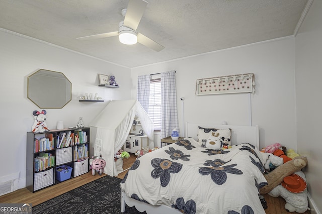 bedroom with wood-type flooring, ceiling fan, a textured ceiling, and crown molding