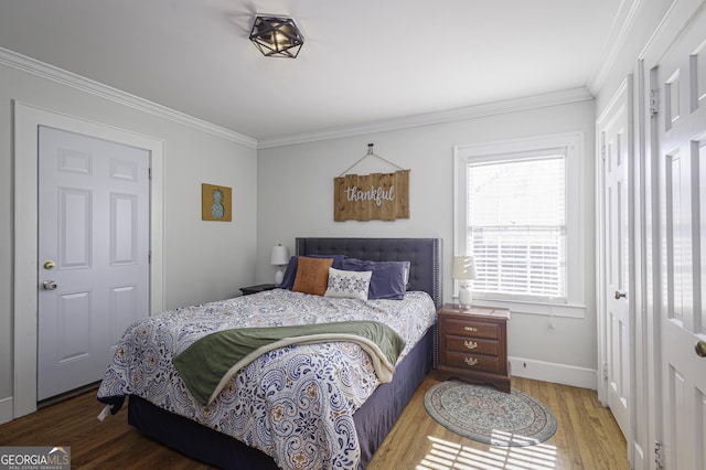 bedroom with ornamental molding and hardwood / wood-style floors