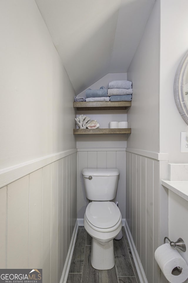 bathroom with vanity, lofted ceiling, hardwood / wood-style floors, and toilet