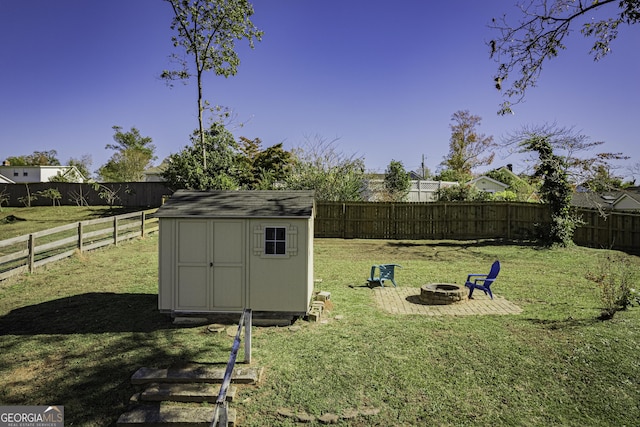 view of yard featuring an outdoor fire pit and a shed