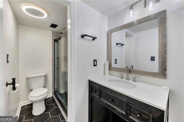 bathroom with tile patterned floors, vanity, toilet, and a shower with door