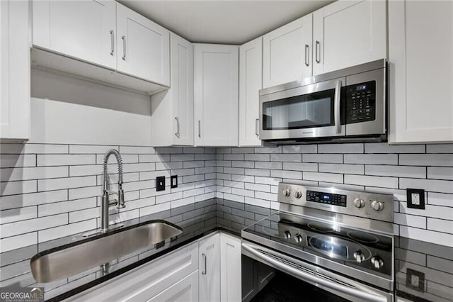 kitchen featuring backsplash, stainless steel appliances, white cabinetry, and sink