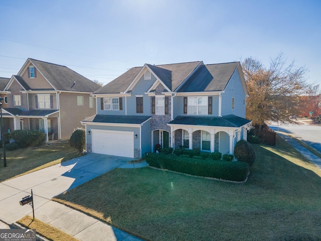 view of front of property featuring a front yard, a garage, and covered porch