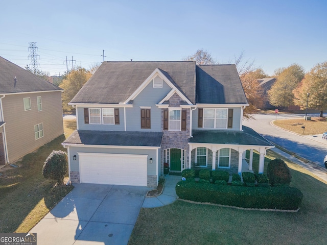 view of front of property featuring a front yard, a porch, and a garage