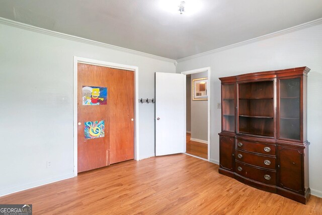 bedroom with hardwood / wood-style flooring, ornamental molding, and multiple windows