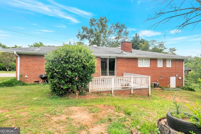 back of property featuring brick siding, a yard, a chimney, central air condition unit, and crawl space