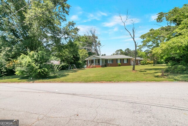 single story home featuring a front lawn and a garage