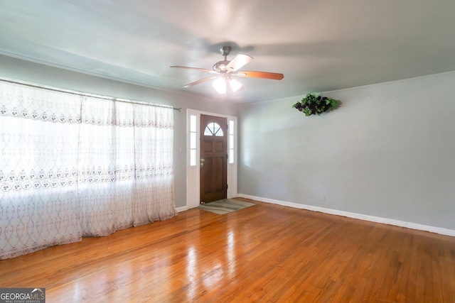 foyer with wood finished floors, a ceiling fan, and baseboards