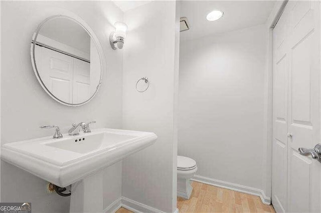 bathroom with hardwood / wood-style flooring and toilet