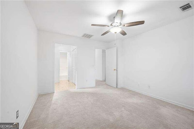 unfurnished room with ceiling fan and light colored carpet