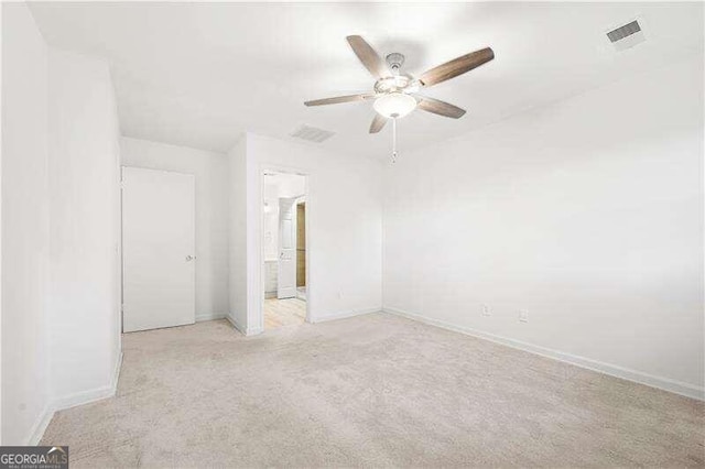 carpeted spare room featuring ceiling fan