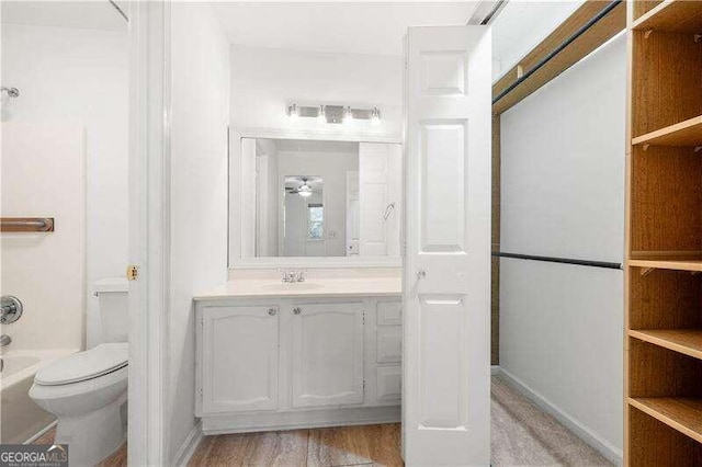 full bathroom featuring hardwood / wood-style flooring, vanity, toilet, and shower / bath combination