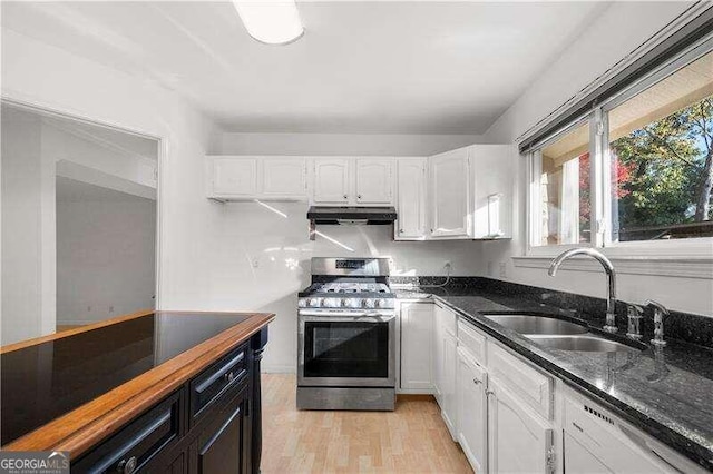 kitchen featuring white cabinetry, sink, dark stone countertops, stainless steel range with gas stovetop, and light wood-type flooring