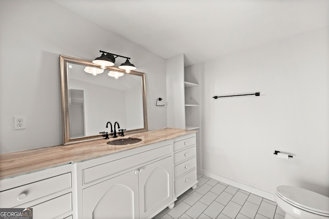 bathroom with tile patterned flooring, vanity, and toilet